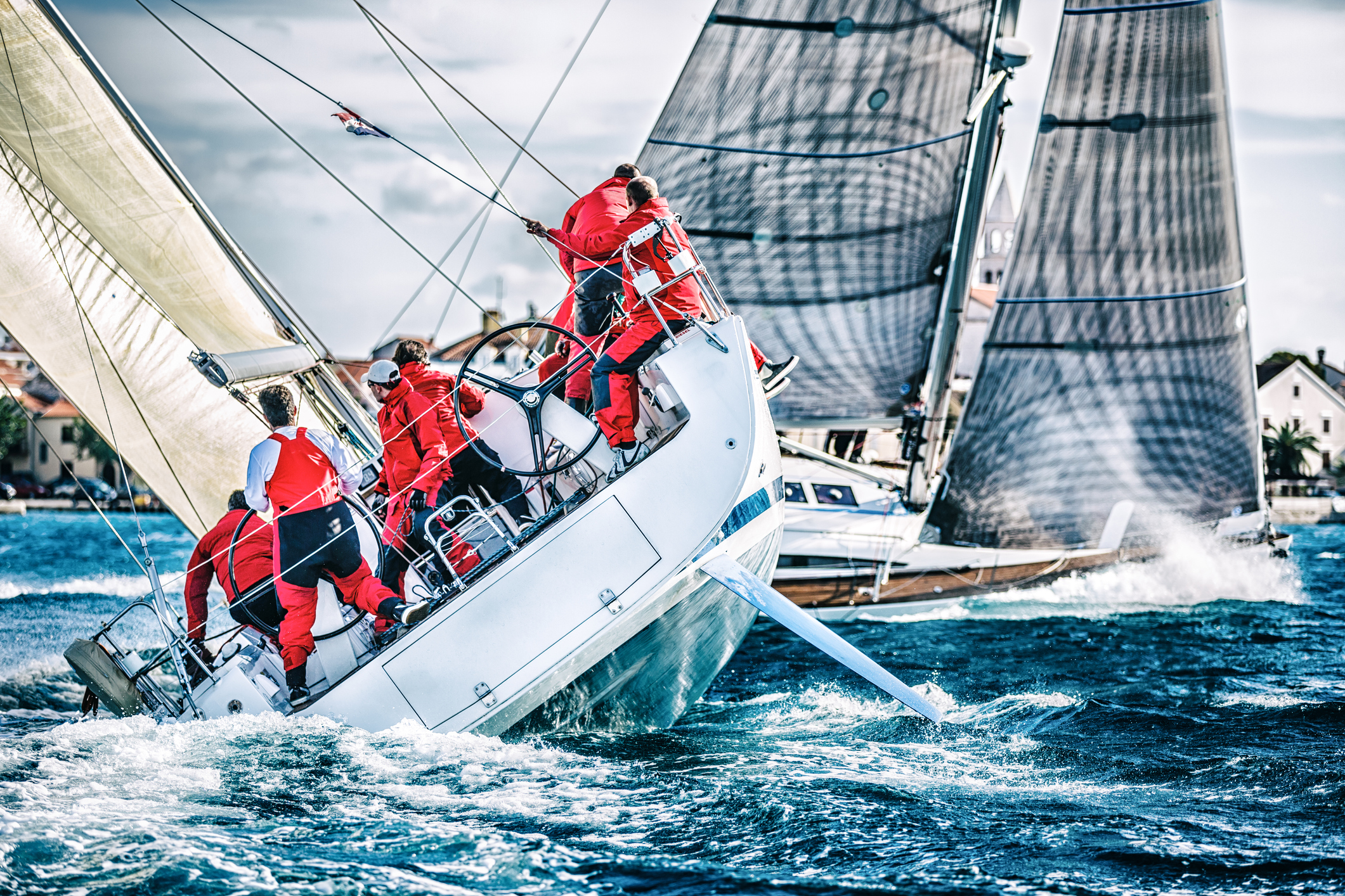 Sailboat Race tacking against the wind with crew in red foul weather gear